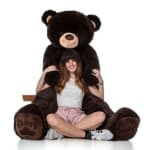 Woman sitting with an oversized teddy bear