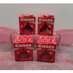 Four boxes of Hershey's Kisses chocolates on pink mesh fabric.