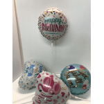 Four foil balloons with birthday and welcome messages.