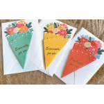 Three floral pop-up greeting cards with envelopes on a wooden surface