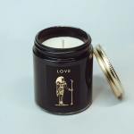 Black candle jar with a gold lid and Egyptian-style label