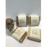 Four wrapped handmade soap bars with a small decorative bird figurine