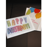 Two birthday greeting cards with colorful balloon designs on a dark surface.