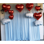 Red heart balloons and white cloud balloons against a light blue drape