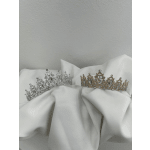 Two jeweled tiaras resting on white fabric