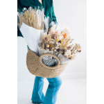 Person holding two dried flower bouquets and a woven basket
