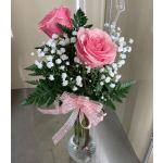 Pink roses with white baby's breath in a clear glass vase with a pink ribbon