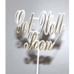 Blurred gold script cake topper on a white stick