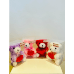 Four plush teddy bears in clear boxes, each holding a red heart
