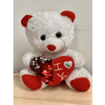 White teddy bear holding a red heart pillow with "I love you" text