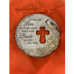 Round memorial plaque with a cross cutout and bird and flower relief