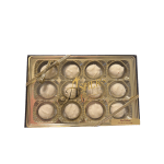 Box of white chocolate-covered truffles in gold trays with a ribbon
