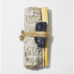 A bundled sage smudge stick tied with twine and decorated with gold and black accents