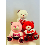 Three plush teddy bears holding heart-shaped "Love" pillows