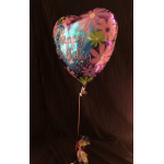 Heart-shaped birthday balloon with colorful flowers and a ribbon tail