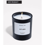 Black scented candle in a glass jar with a lit wick