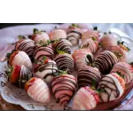 Plate of chocolate-covered strawberries with pink and white drizzle