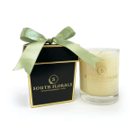 Cream-colored glass jar candle with black gift box tied with a green satin bow