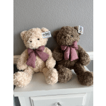 Two plush teddy bears with gingham bows sit side by side.