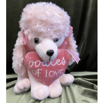 Pink teddy bear holding a heart that says "oodles of love"