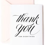 White thank you card with black script lettering and pale pink envelope