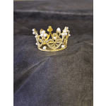 Gold crown with pearl accents on a dark surface