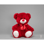 Red teddy bear with a satin bow on a gray background