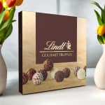 Lindt gourmet truffles box flanked by tulips in vases