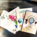 Assorted greeting cards in plastic sleeves, including birthday and retirement designs.