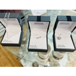 Three open jewelry boxes with necklaces on a glass table