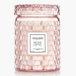 Pink glass candle jar with a lid and label reading Rose Otto