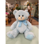 Light blue teddy bear with a ribbon bow sitting on a counter
