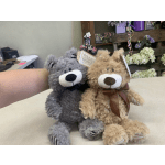 Two plush teddy bears sitting side by side on a counter.