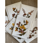 Pressed floral art on white paper sheets in clear sleeves