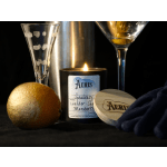 Lit candle with a gold ornament and two champagne glasses
