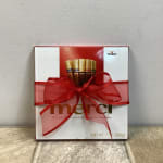 Box of Merci assorted chocolates wrapped with a large red bow
