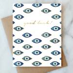 Greeting card with blue eye motifs and the words "good luck!"