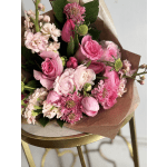 Pink mixed bouquet with roses and tulip buds wrapped in brown paper
