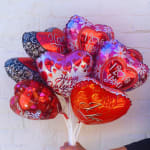 Heart-shaped Valentine balloons in red, pink, and purple