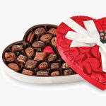 Heart-shaped box of assorted chocolates with a red lid and white ribbon