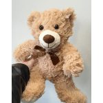 Tan teddy bear with a brown ribbon bow