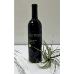 Wine bottle beside an air plant on a marble surface