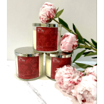 Three peony-scented candles with pink peonies arranged around them