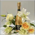 Gold prosecco bottle surrounded by cream and yellow flowers