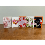 Five floral greeting cards with Valentine messages on a wooden table.