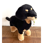Plush black-and-tan dog toy standing on a wooden floor