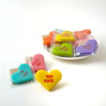 Colorful heart-shaped candies with messages on a white surface