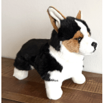 Plush tricolor corgi figurine standing on a wooden surface