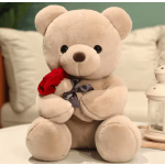 Plush teddy bear holding a red rose and wearing a ribbon