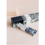Hand cream tube beside a patterned gift box